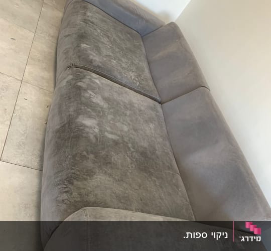 ספה אפורה עם כתמים על הרצפה